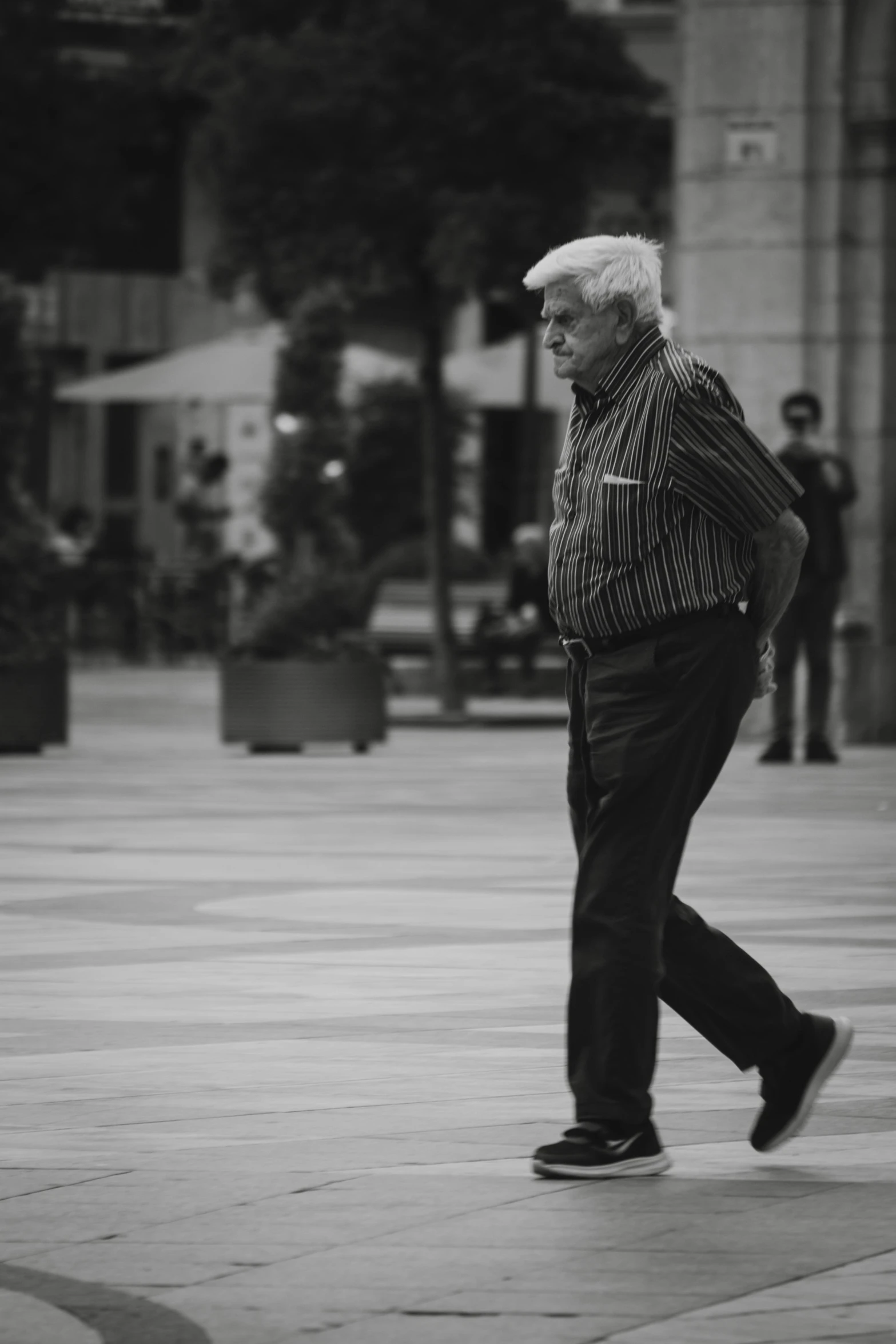 an older man is walking through the sidewalk