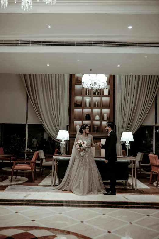 a man and woman in wedding outfits standing next to a table