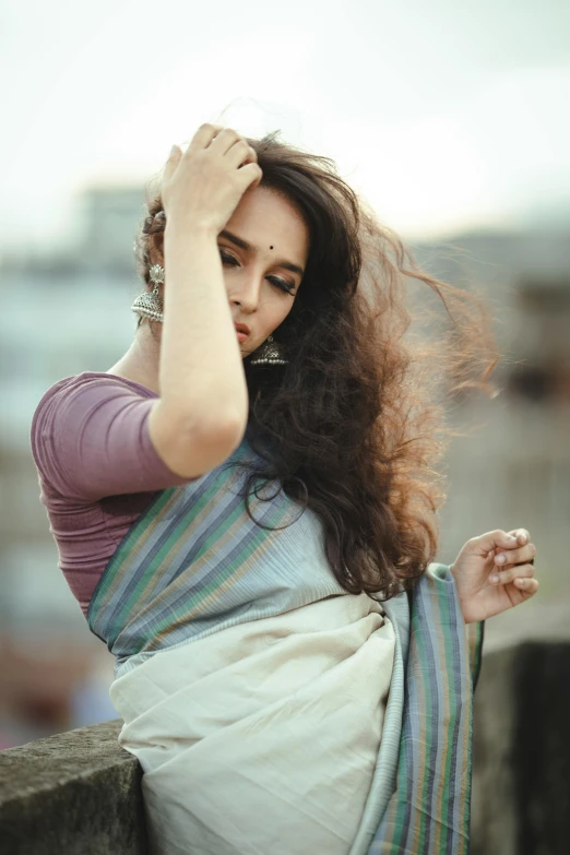 a woman is sitting on the wall in a saree