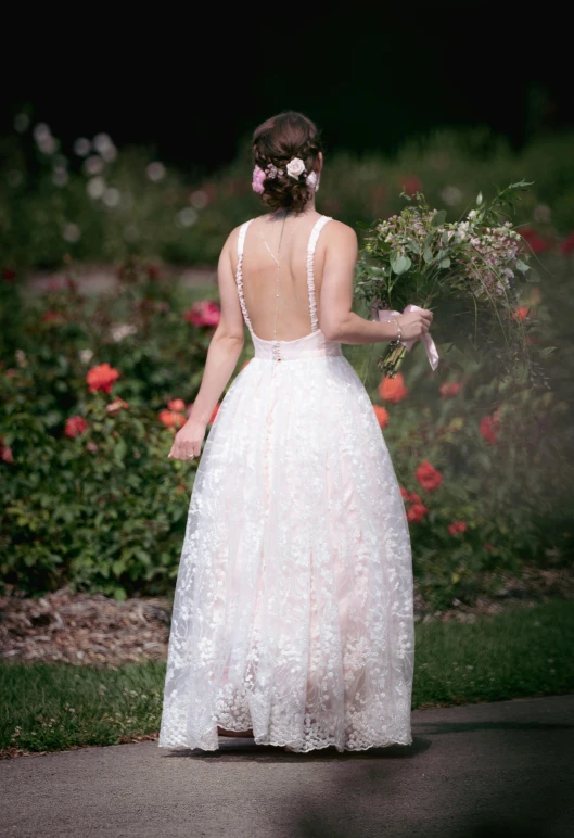 a bride walks down the street wearing her wedding dress