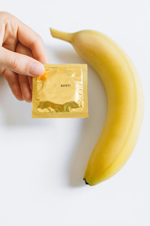 a person holding a packet of protein and a banana