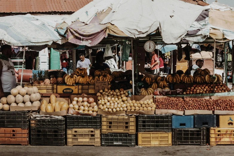 fruit stands and a large white umbrella with people on it