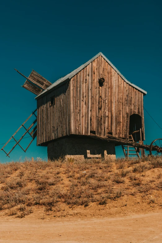 an old fashioned wooden building on top of a hill