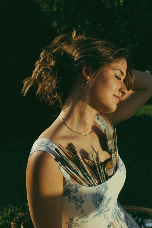 a young woman holds her hair back by the side