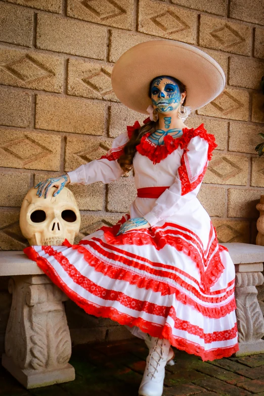 a skeleton sitting on top of a bench next to a woman in a red and white dress