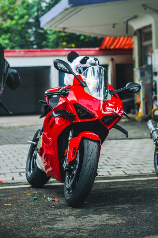 a red motorcycle parked in front of a store