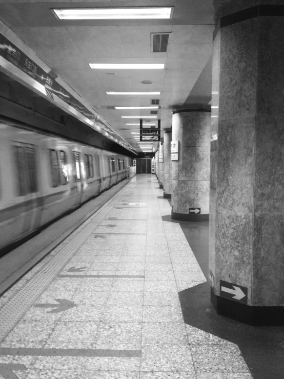 a monochrome po of a subway car at a station