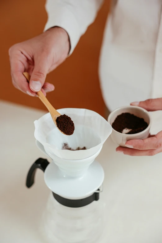 a person scoops brown sugar into a gravy pot