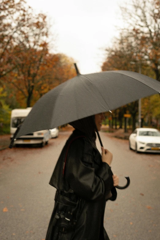a woman walking in the rain with an umbrella
