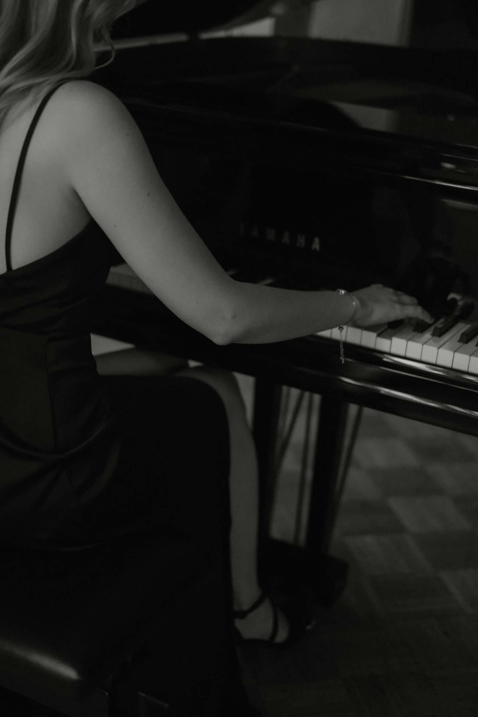 a woman is sitting at a piano in a black dress