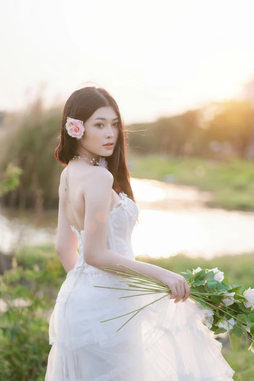 a woman in a wedding dress holding white flowers