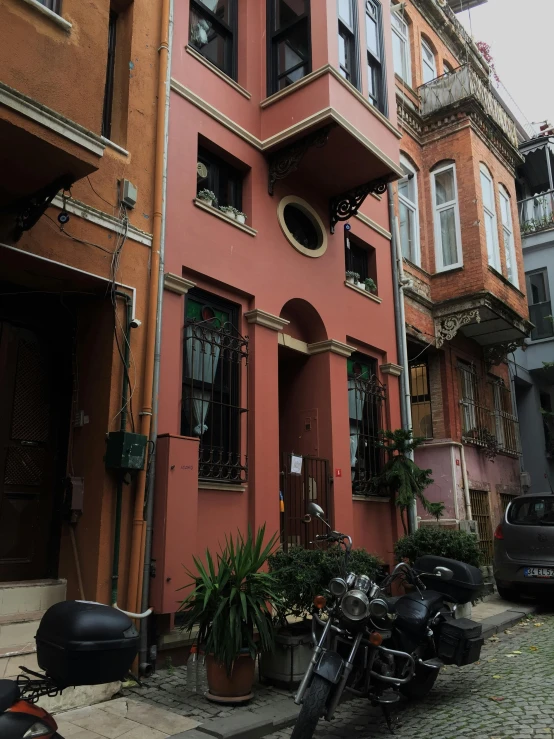 two motor bikes parked on the sidewalk outside some buildings