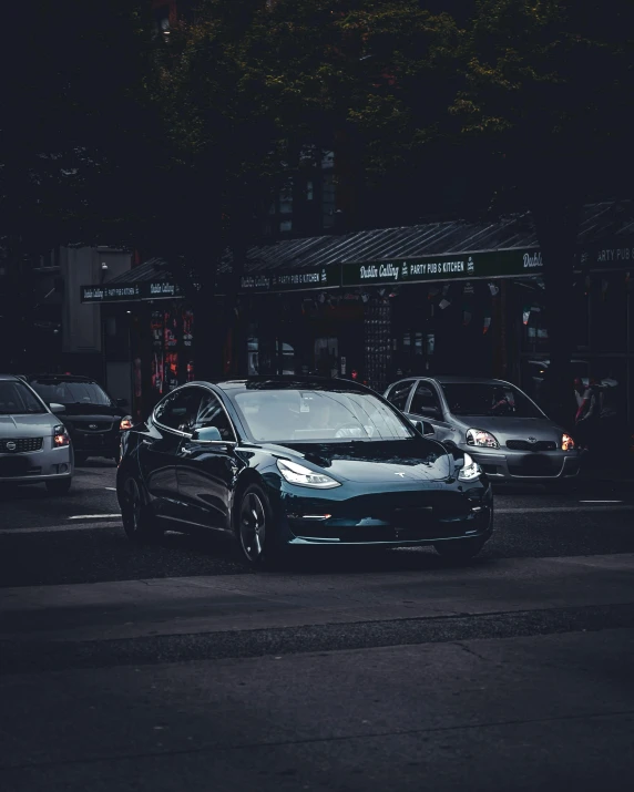 a black car sitting on the side of a road