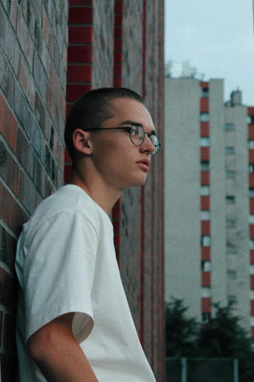 a person leaning on a brick wall next to a building