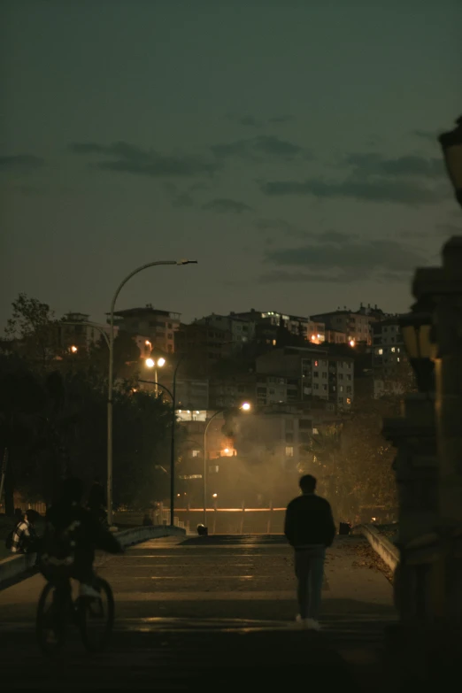 a man walking across the street at night time