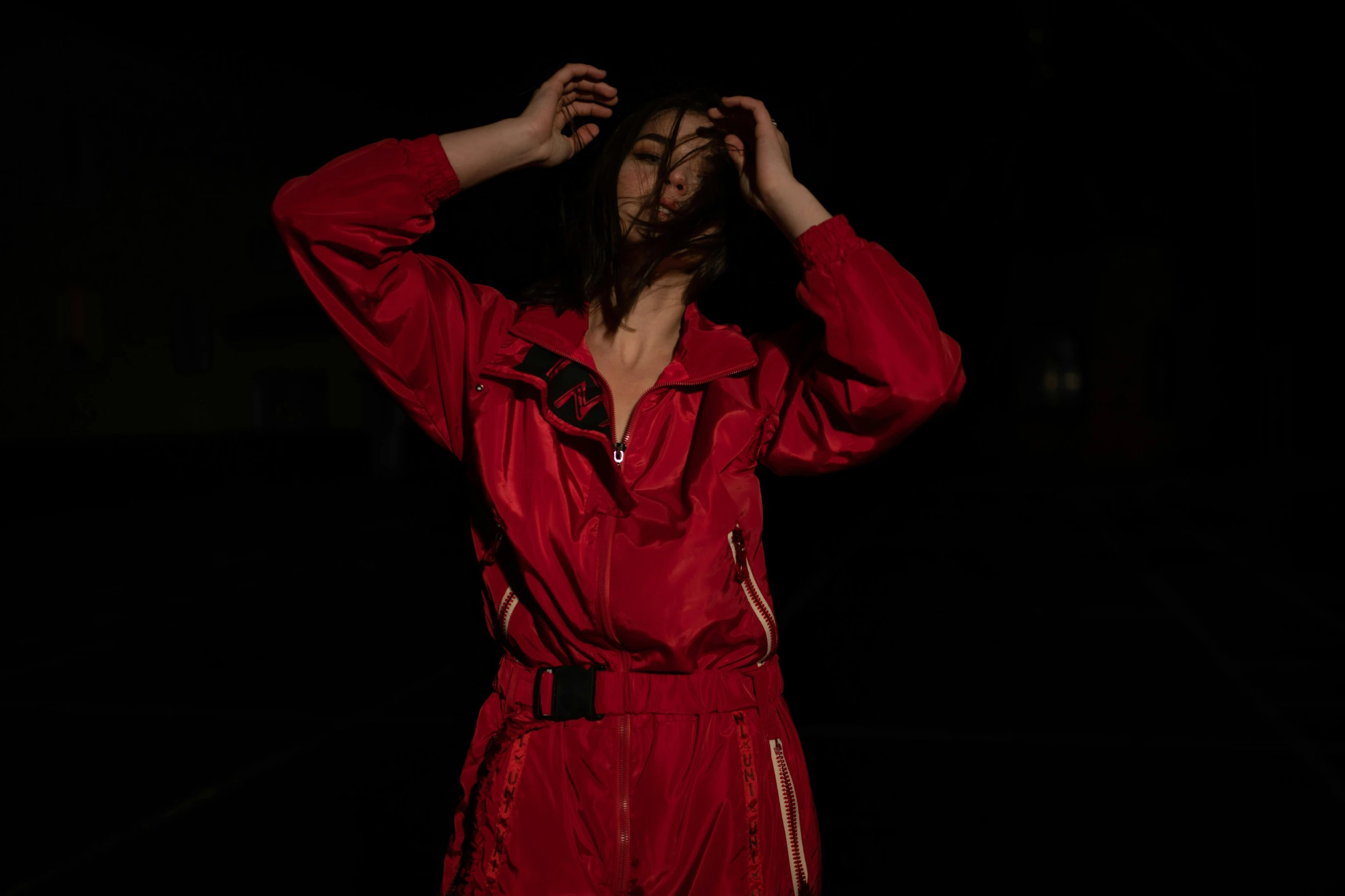 a man with long hair in a red suit is looking up