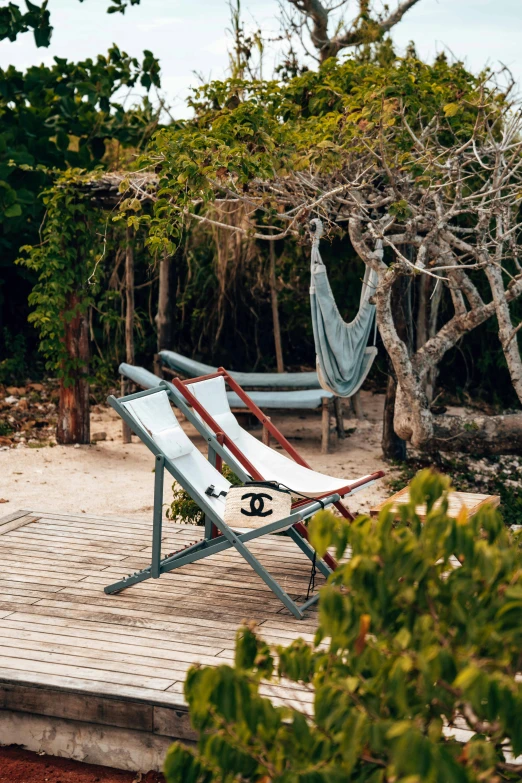 two chairs on a wooden deck surrounded by trees