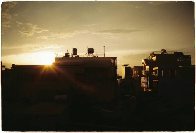 buildings with rooftops during the sunrise with the sun behind