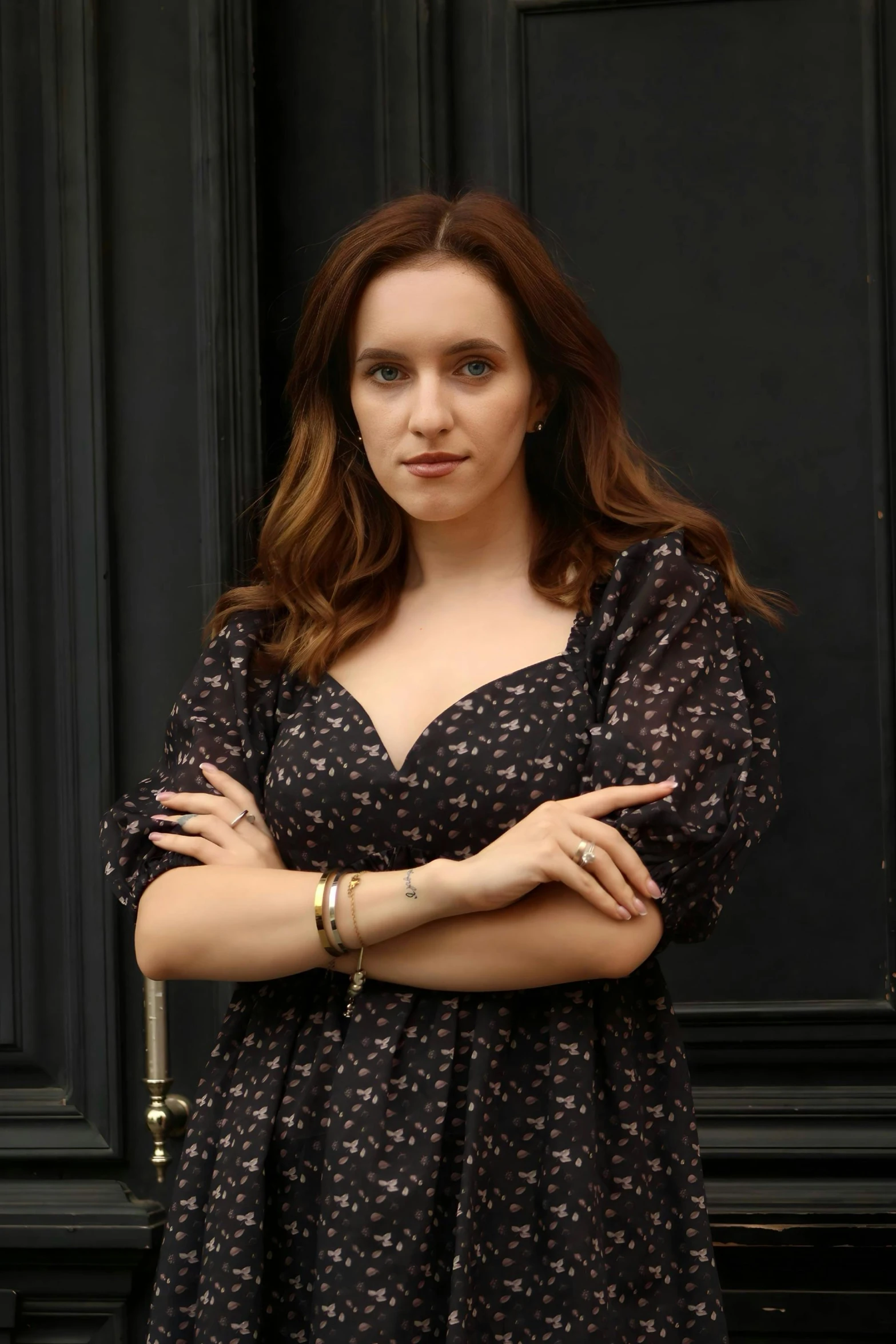 a woman in a black dress standing near a door