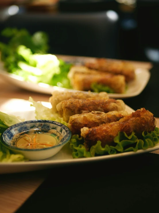 plates filled with various foods including salads and dipping sauce