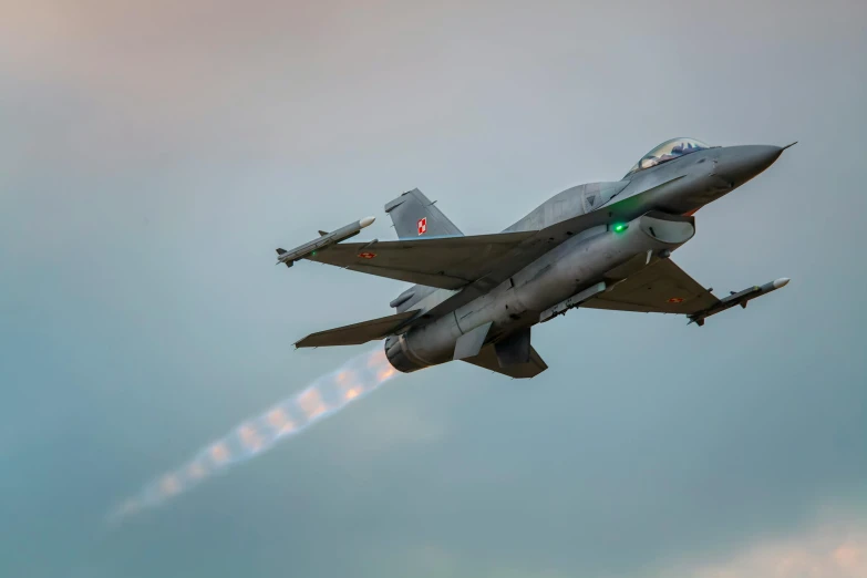 a jet fighter flying through the sky during the day