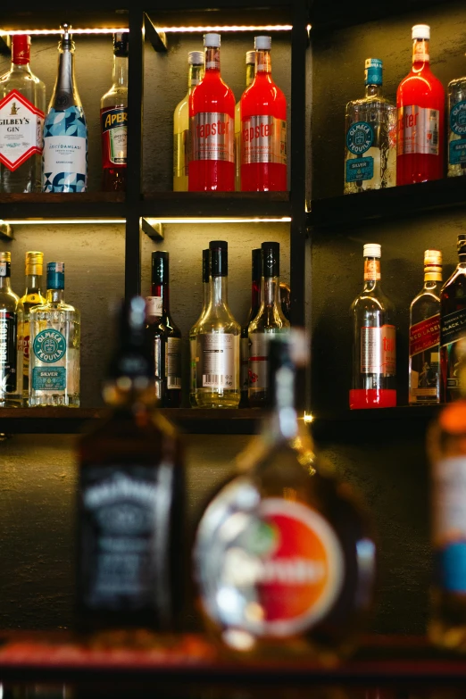 many different liquor bottles and glasses are displayed