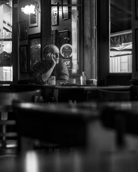 a man sitting at a table talking on a phone