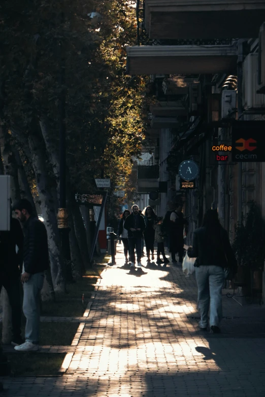 a long sidewalk in a city area with people walking on it