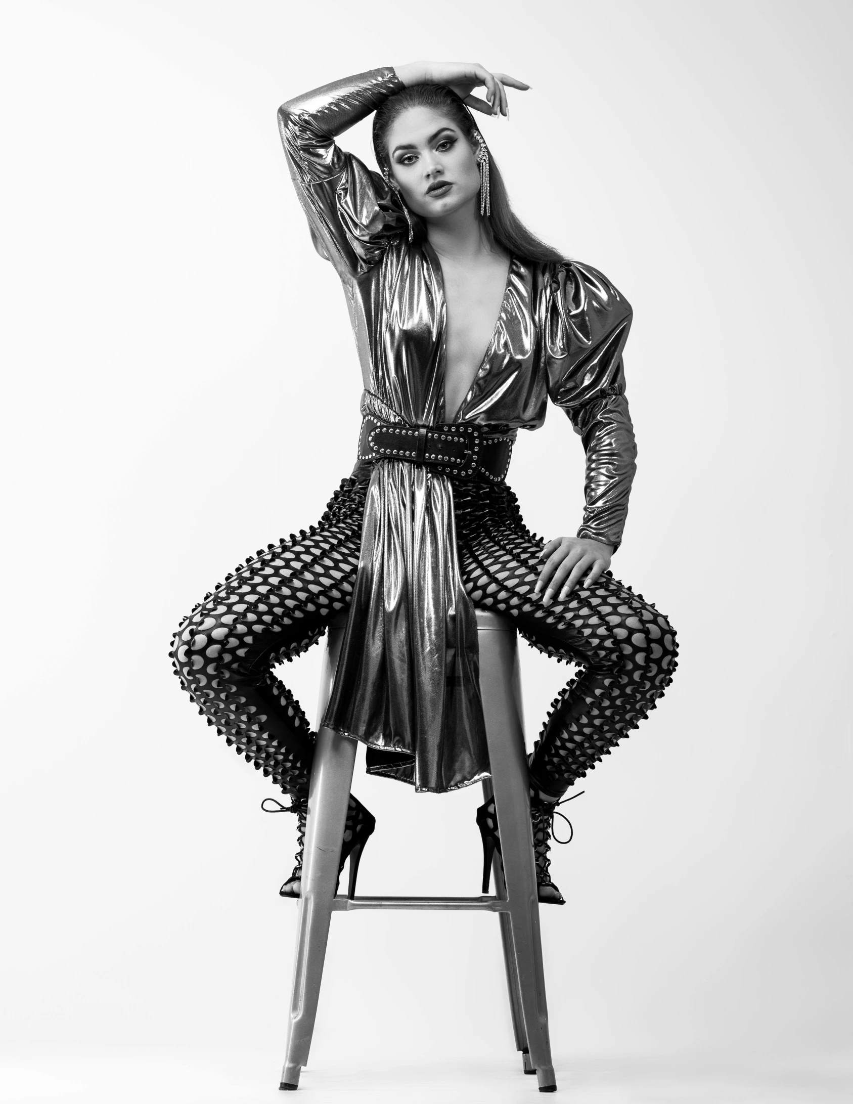 a model sitting in a chair wearing an unusual looking outfit