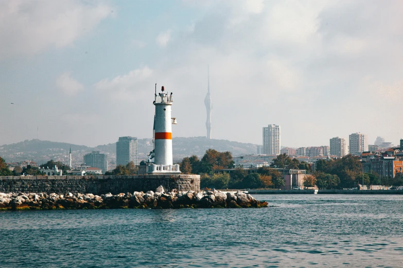 a lighthouse with trees in the background in the water