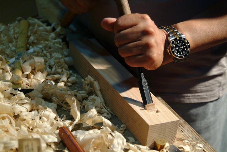 the man is sharpening a watch on the wood