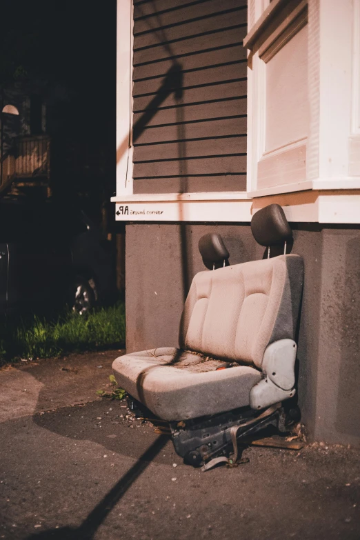 old fashioned chair with a broken arm sitting on the side of the road