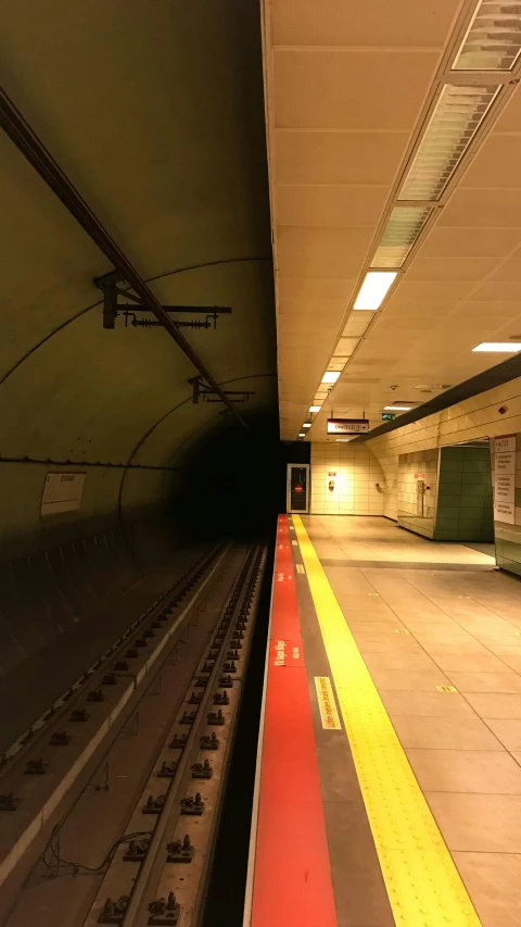 an empty subway station has a light at the end