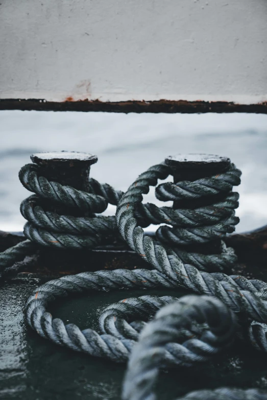 a stack of ropes sit near the ocean