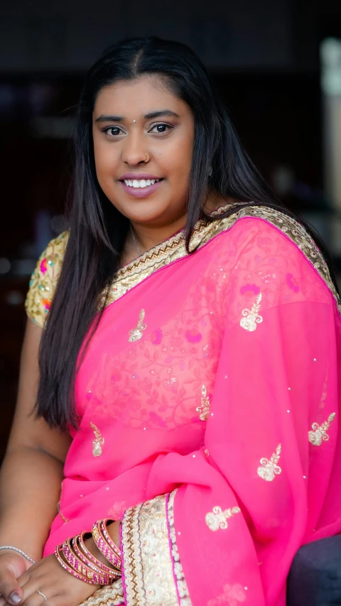 a beautiful young woman wearing a pink sari