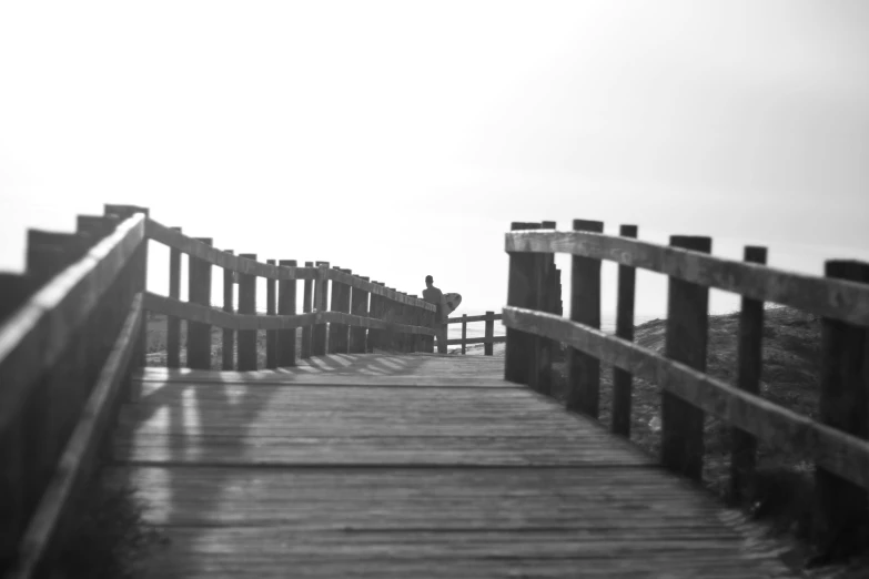 a black and white po of a person standing on a bridge