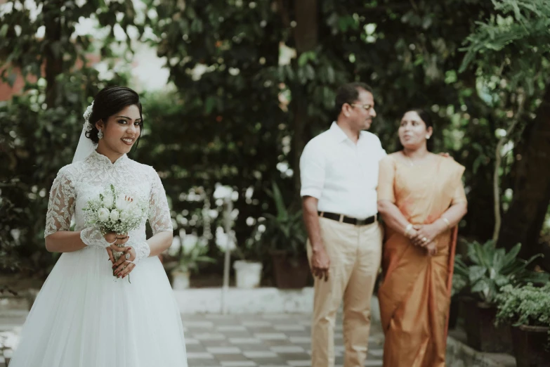 a bride walks in front of two other people