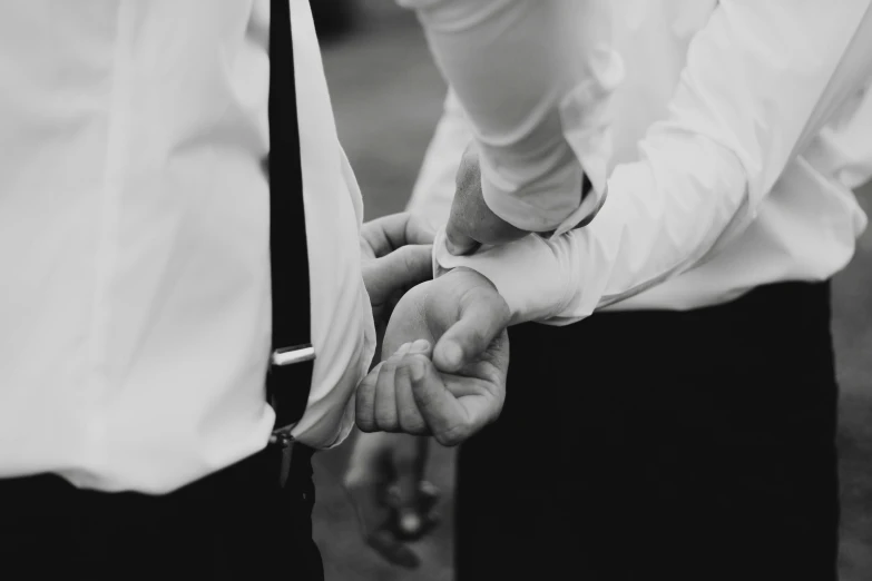 a black and white po of a man holding a hand of another man