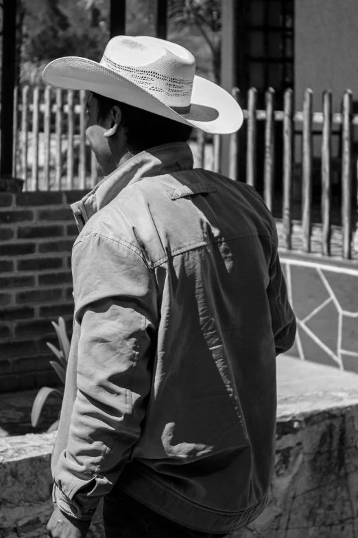 a man wearing a cowboy hat looking into the distance