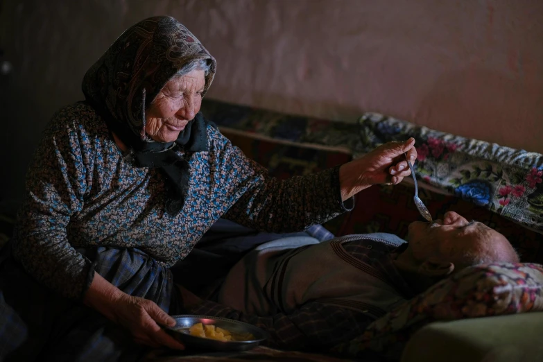 an older woman sitting next to a man eating