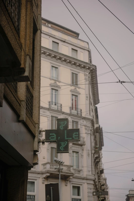 a cross light is hanging from a building