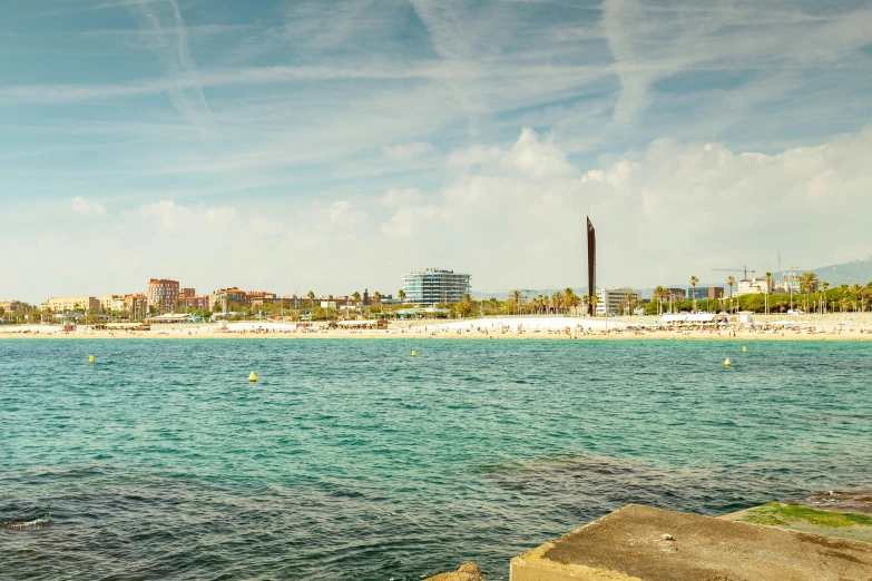 a sandy beach with buildings on the horizon