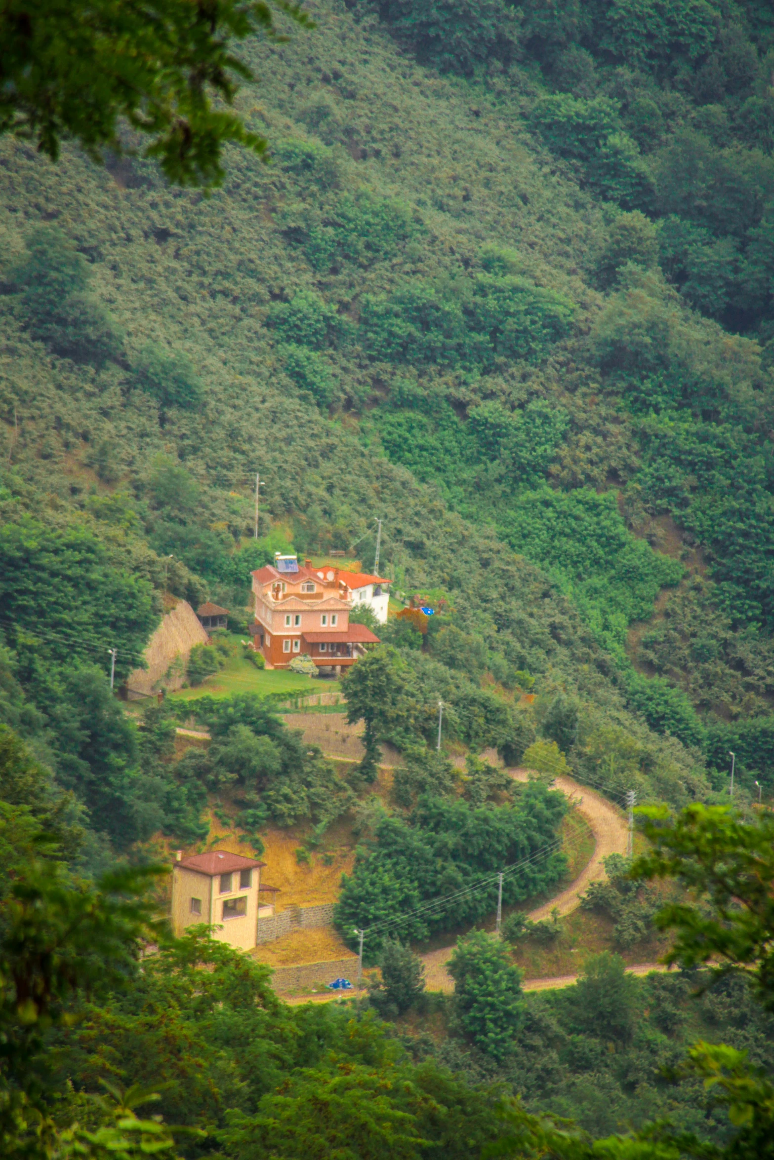 a large home on the side of a green hillside