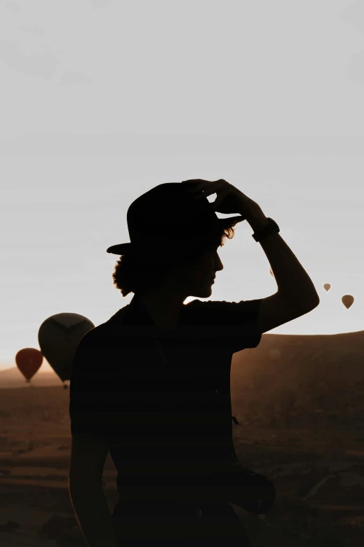 a woman looking out at some  air balloons