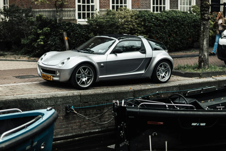 a silver sports car is parked along the side of a street