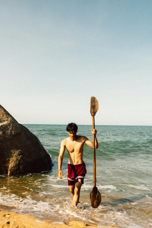 a man running out of the water with a paddle