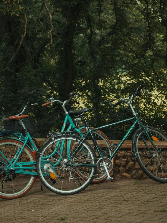 three bikes locked up outside together near a stone wall