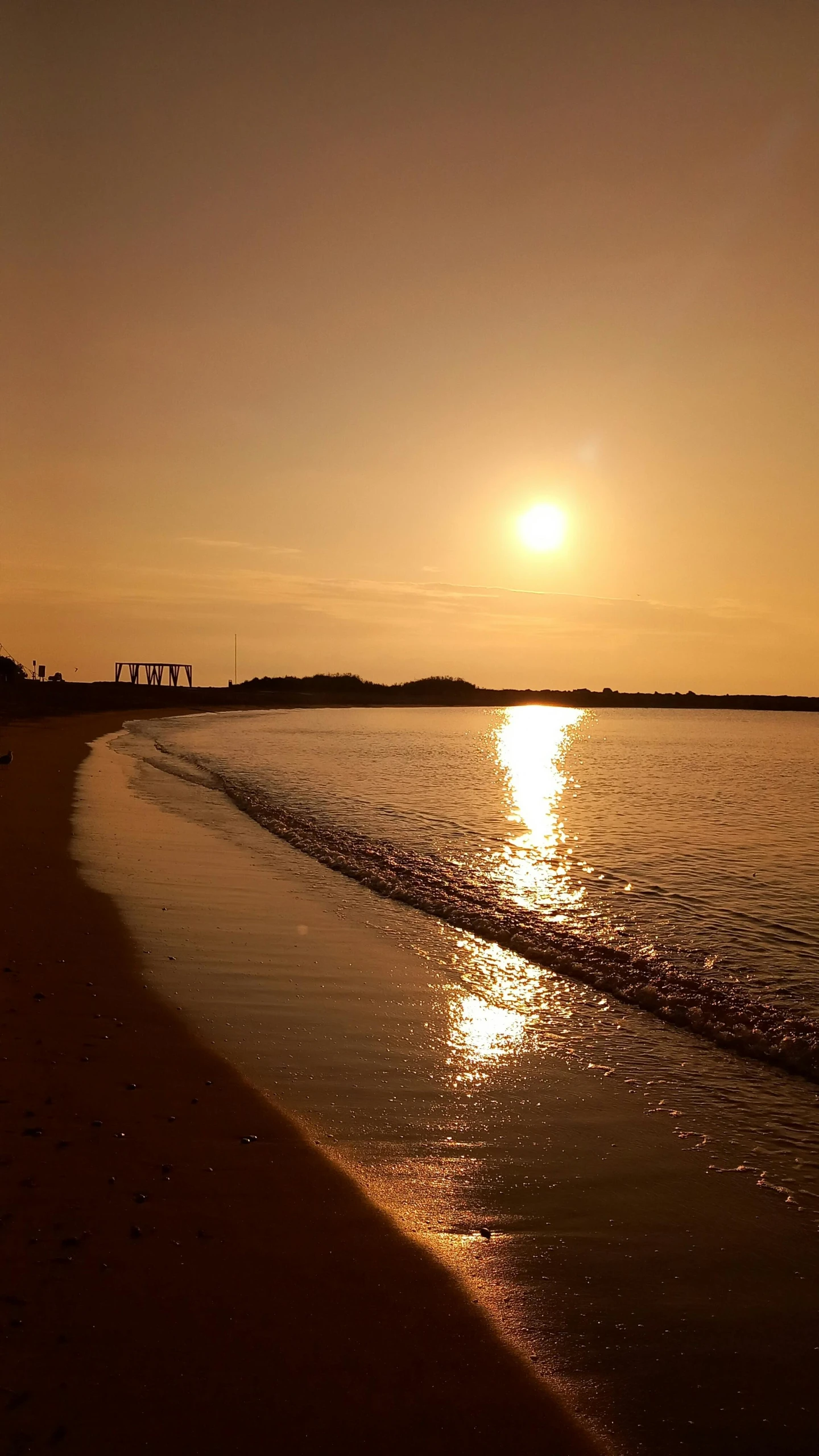 a sun setting at the ocean with the waves coming in