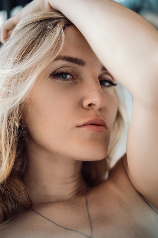 a woman is posing with her hand over her shoulder