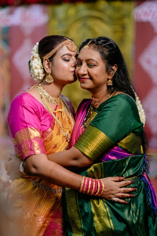 two women dressed in green and pink emce